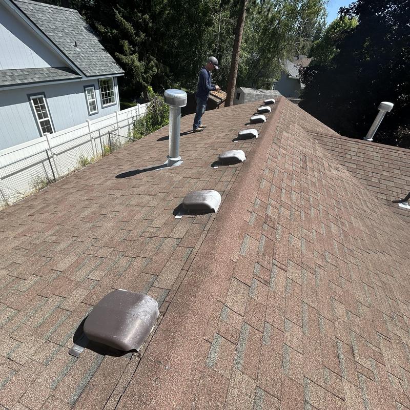 Asphalt shingle roof showing vent caps and ridge line Asphalt shingle roof showing vent caps and ridge line