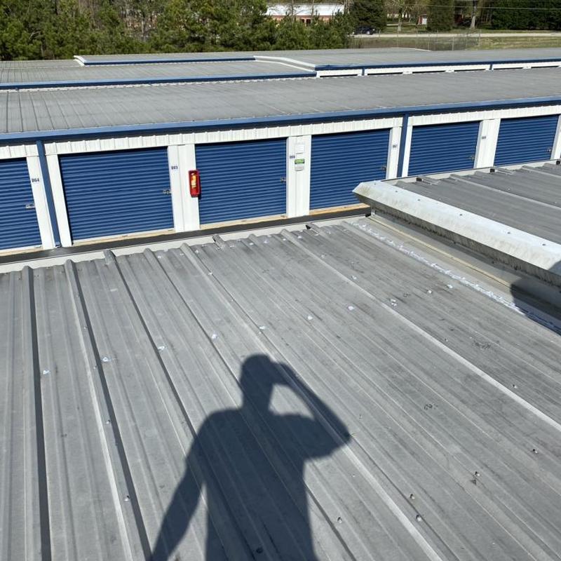 Metal storage unit roof with repaired leaks and new washers