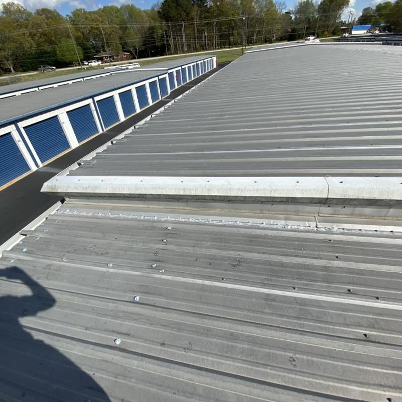 Metal roof panels with replaced neoprene washers and sealant