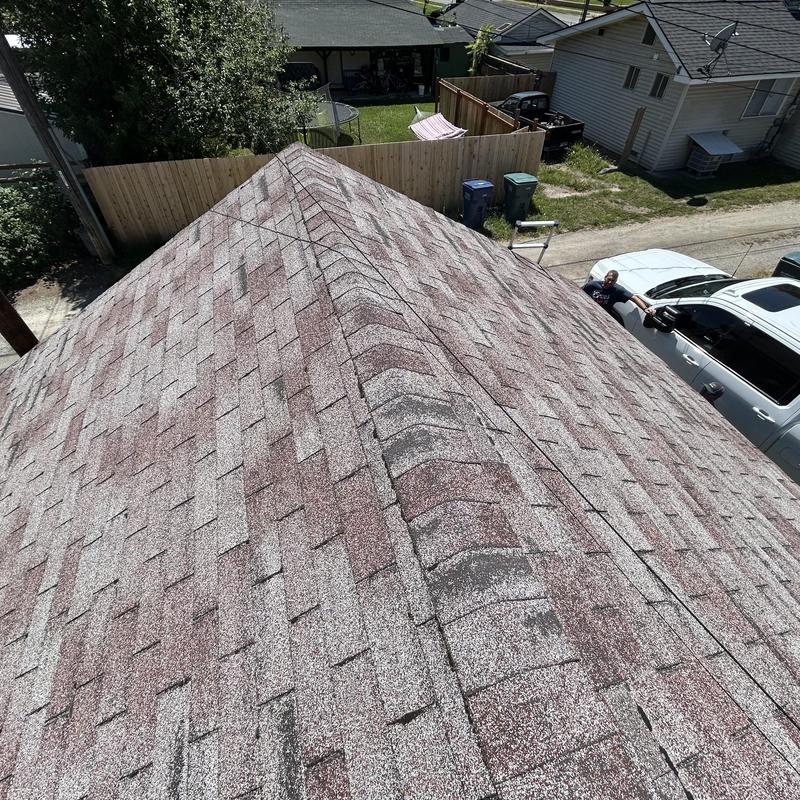 Asphalt shingle roof ridge on residential building Asphalt shingle roof ridge on residential building