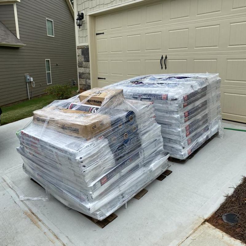 Roof shingles and underlayment pallets wrapped in plastic