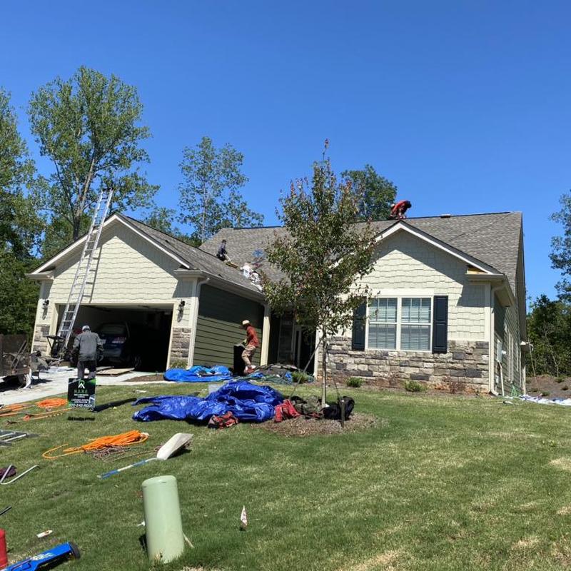 Roof shingles replacement with ladders and workers