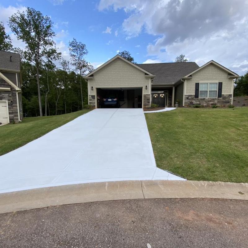 Concrete driveway with garage and lawn in suburban home
