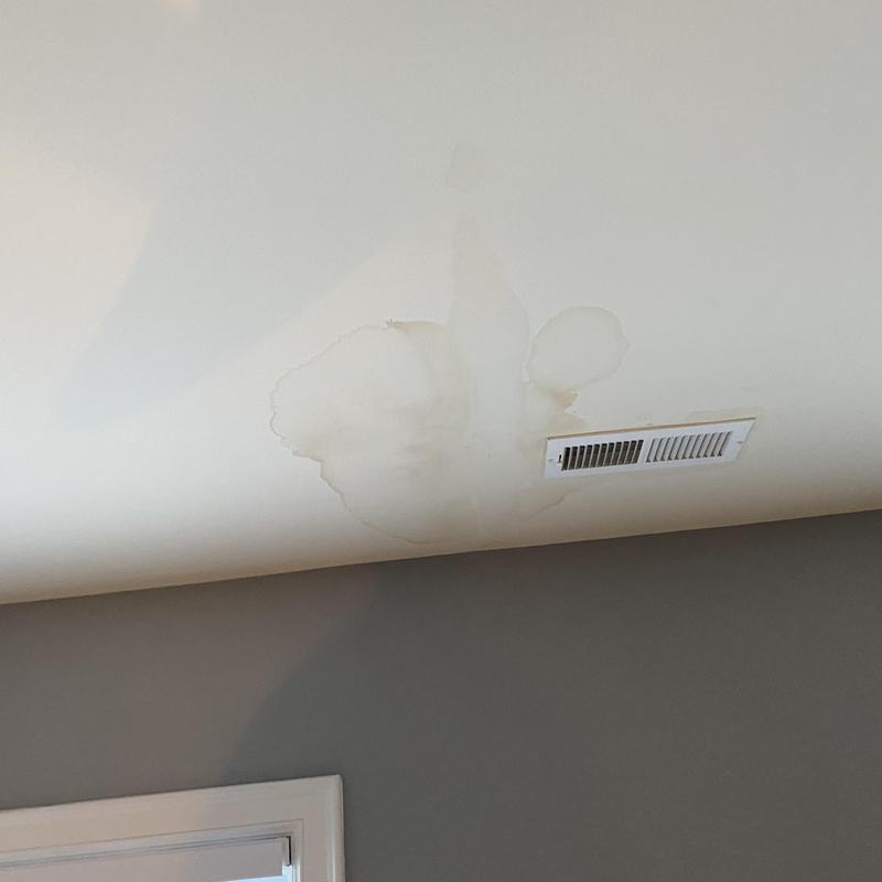 Drywall ceiling with water stains near air vent