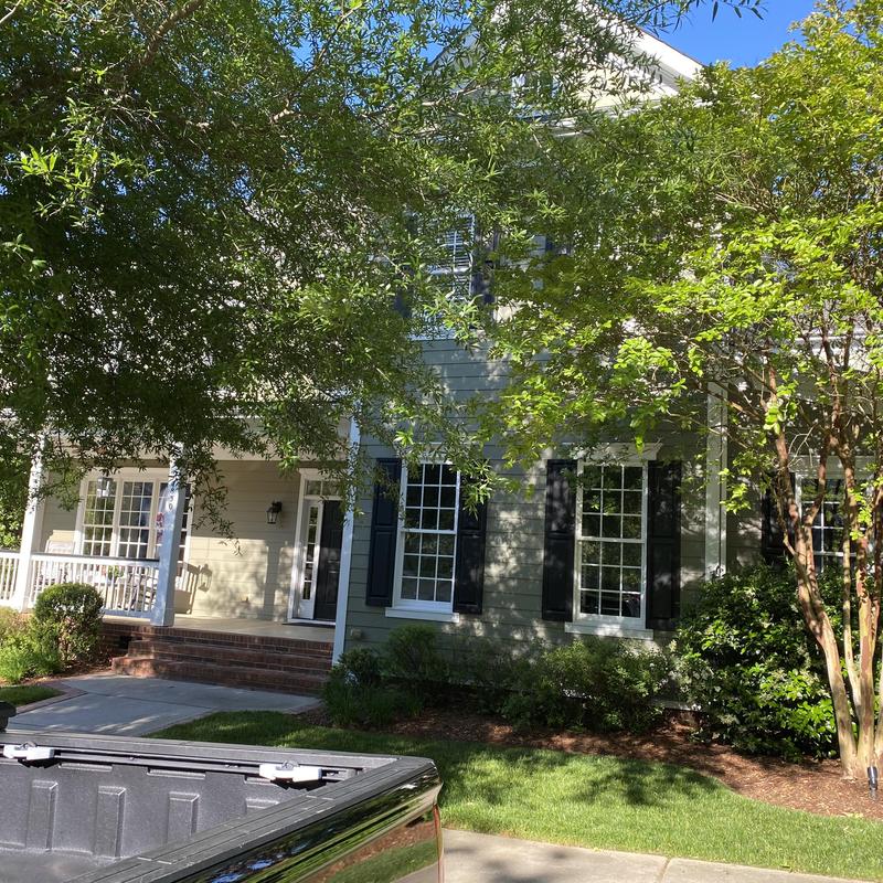 House roof and porch exterior with surrounding trees