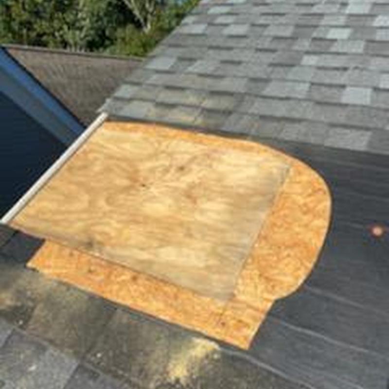 Roof decking replacement with removed shingles nearby