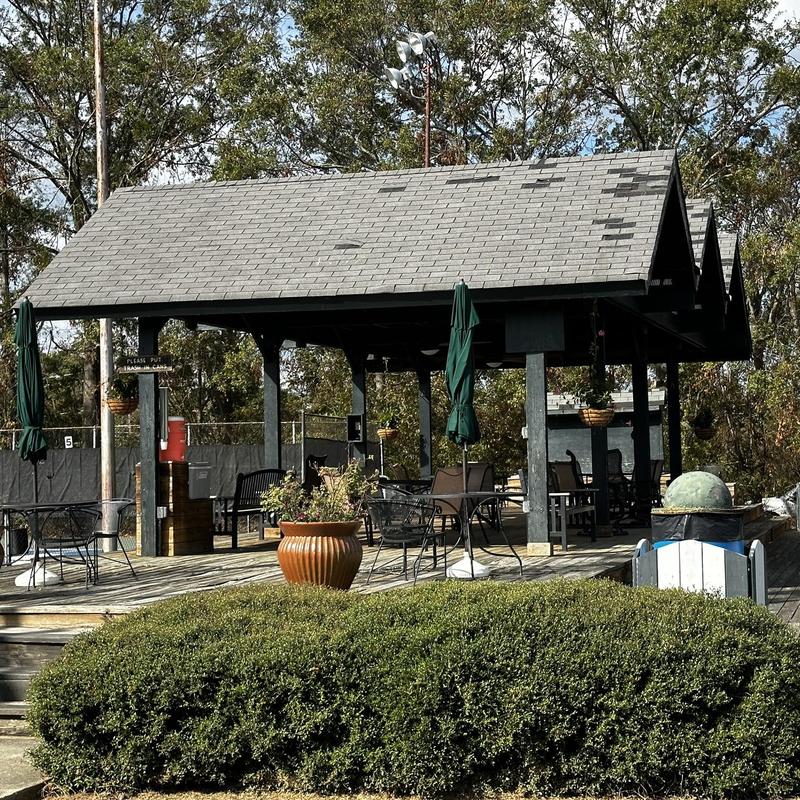 Roof with missing and damaged shingles on pavilion structure