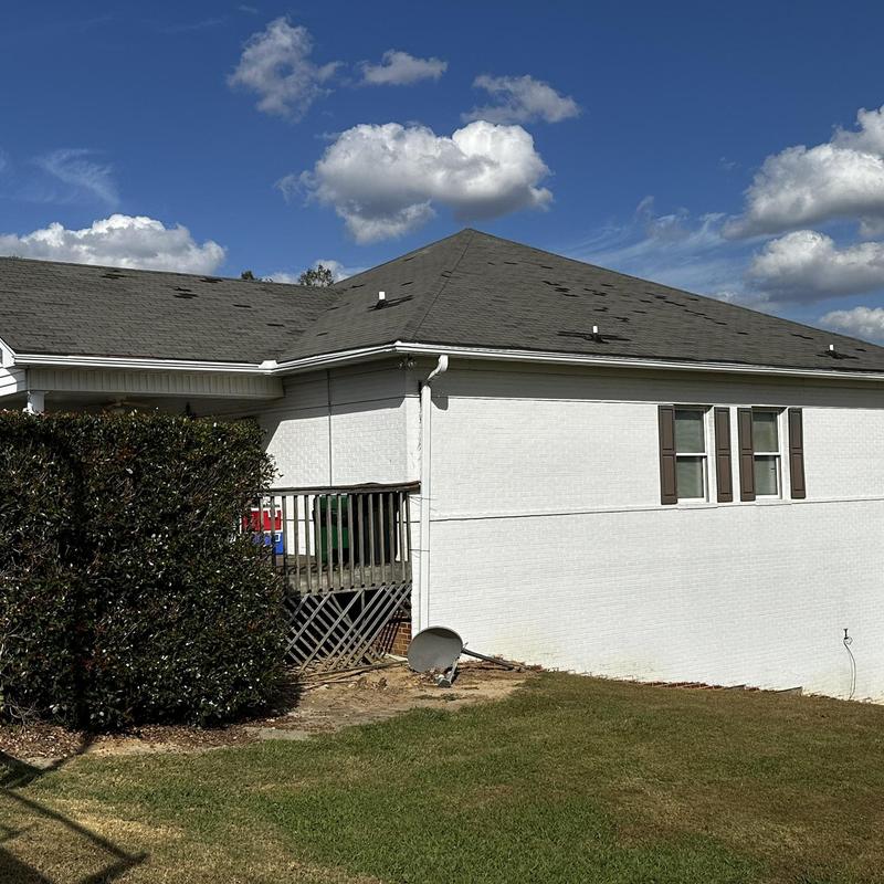 Roof shingles with visible hurricane damage on residential home