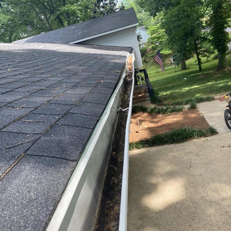 Gutters secured to fascia with fixed shingle overhang