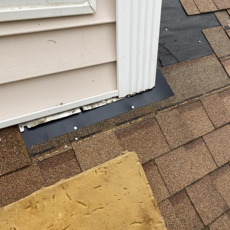 Step flashing behind siding on roof edge