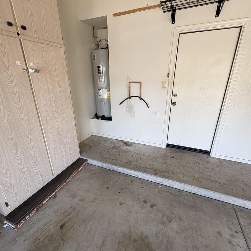 Water heater installed in garage corner next to door