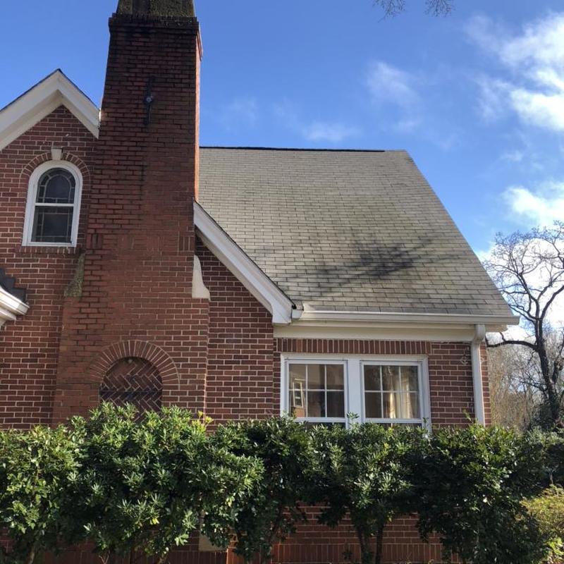 Asphalt shingle roof and brick chimney on house