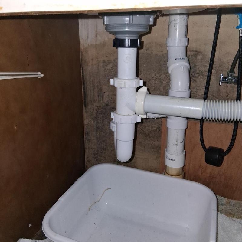 Sink drain trap and piping under cabinet with basin