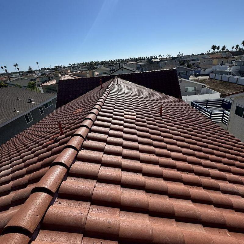 Tile roof with ridge cap and vent pipes in daytime Tile roof with ridge cap and vent pipes in daytime