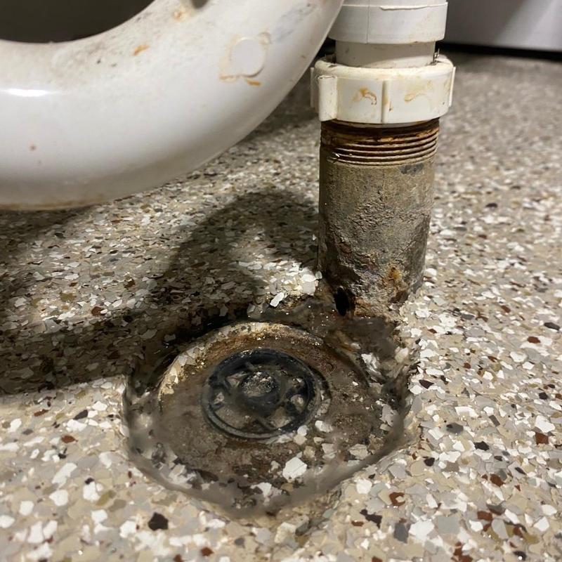 Laundry tub drain line with rusted pipe and floor drain Laundry tub drain line with rusted pipe and floor drain