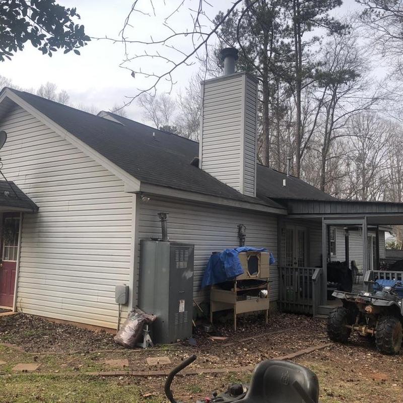 Roof with asphalt shingles and chimney in backyard
