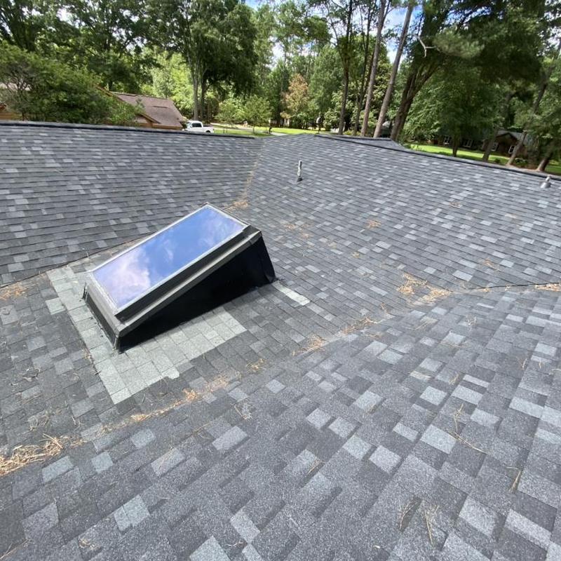 Skylight and roof shingles on residential home roof