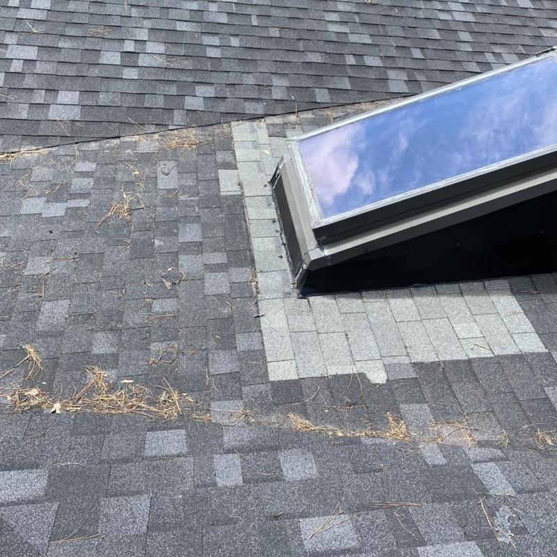 Skylight with sealed flashing on asphalt roof shingles