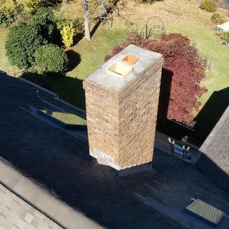 Brick chimney and asphalt shingle roof view