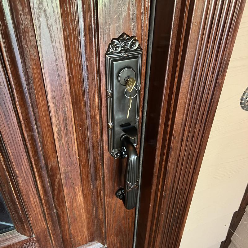 Emtek door handle set with key in lock on wooden door