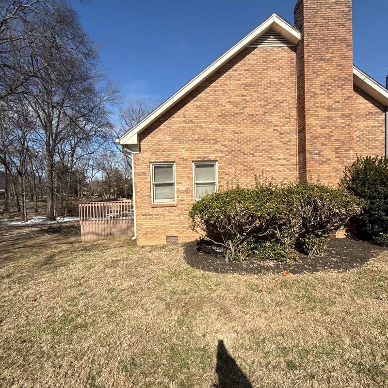 Brick exterior wall with chimney and windows