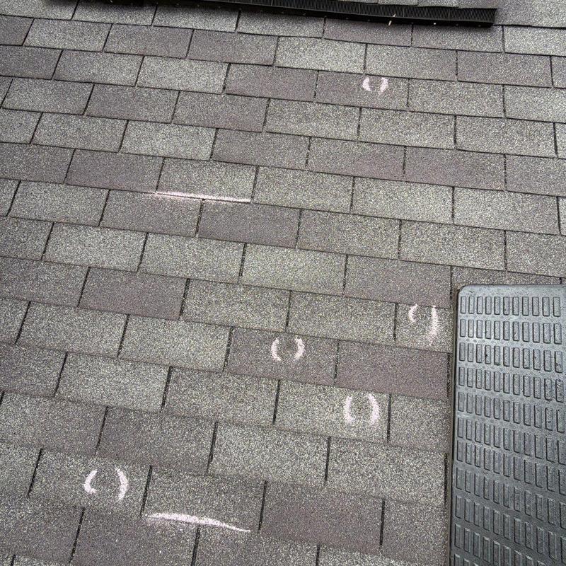 Asphalt roof shingles with hail damage markings