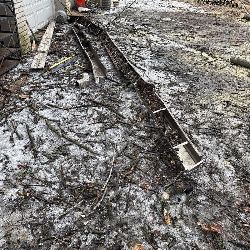 Gutter system debris and hail damage near garage door