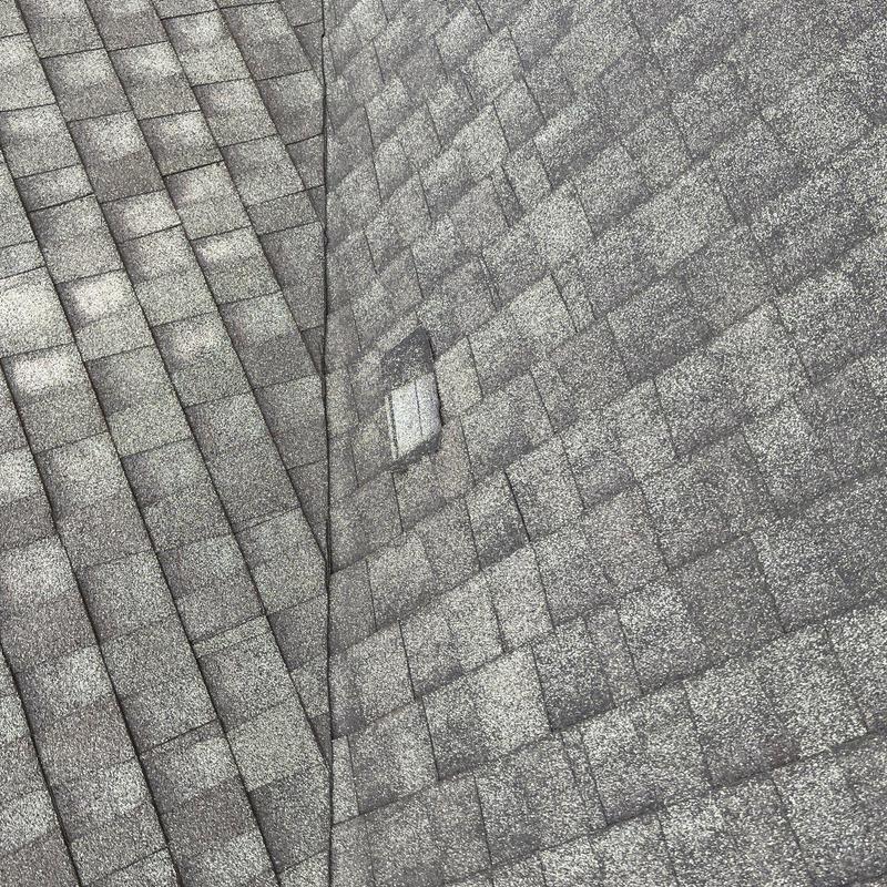 Roof shingles showing hail damage near valley flashing