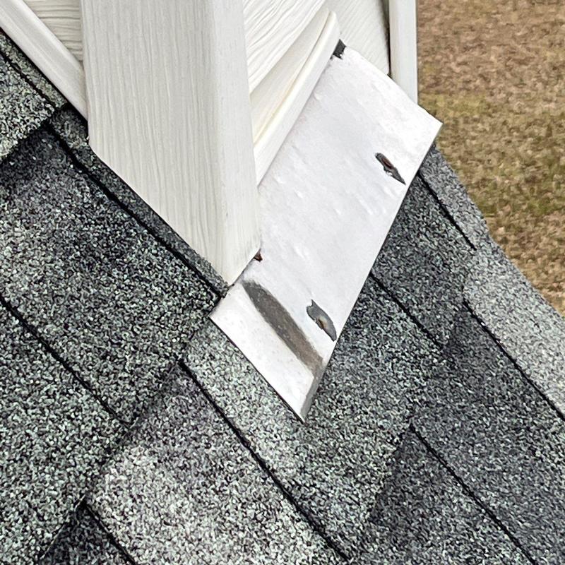 Roof flashing with hail damage on asphalt shingles