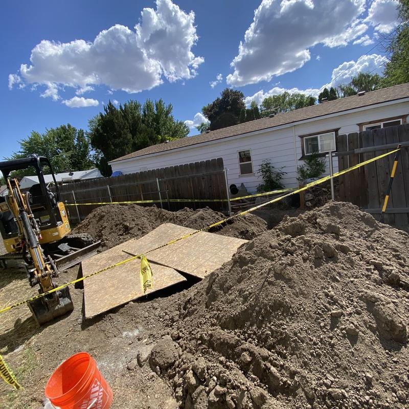 Building sewer replacement site with excavation equipment Building sewer replacement site with excavation equipment