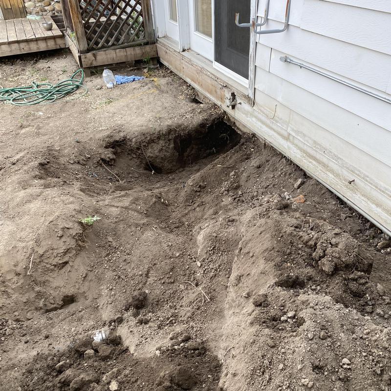 Building sewer trench excavation alongside house exterior wall Building sewer trench excavation alongside house exterior wall