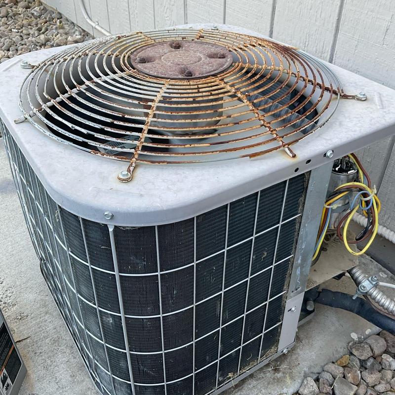 A/C condenser unit with rusted fan guard and wiring exposed A/C condenser unit with rusted fan guard and wiring exposed