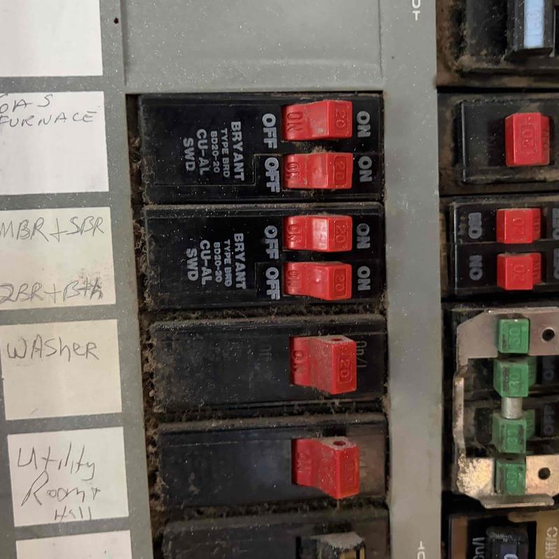 Circuit breaker panel with red switches on labeled slots Circuit breaker panel with red switches on labeled slots