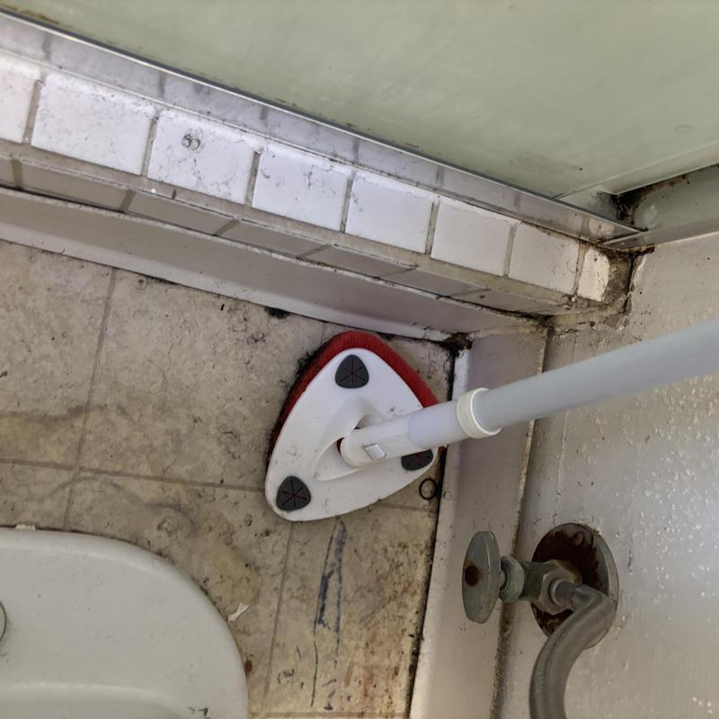 Floor drain cleaning tool near valve in tiled corner