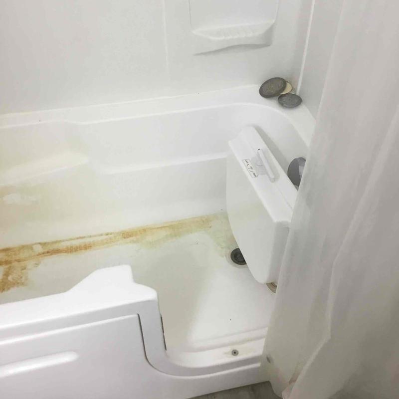 Walk-in bathtub with rust stains and no fill spout