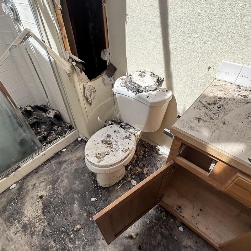 Toilet and bathroom plumbing damage with debris and soot Toilet and bathroom plumbing damage with debris and soot