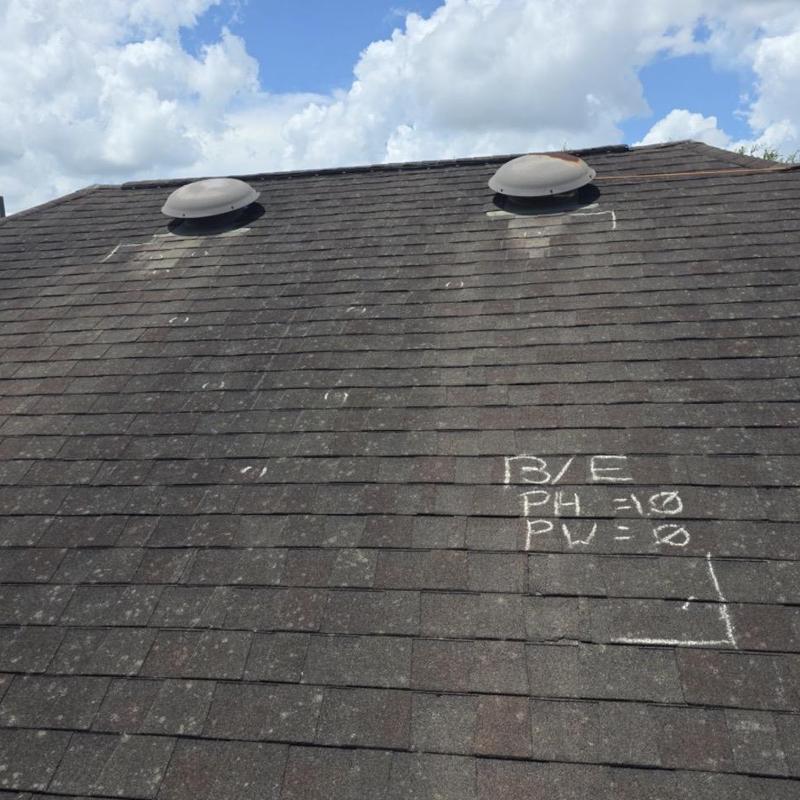 Asphalt shingle roof with chalk markings for damage