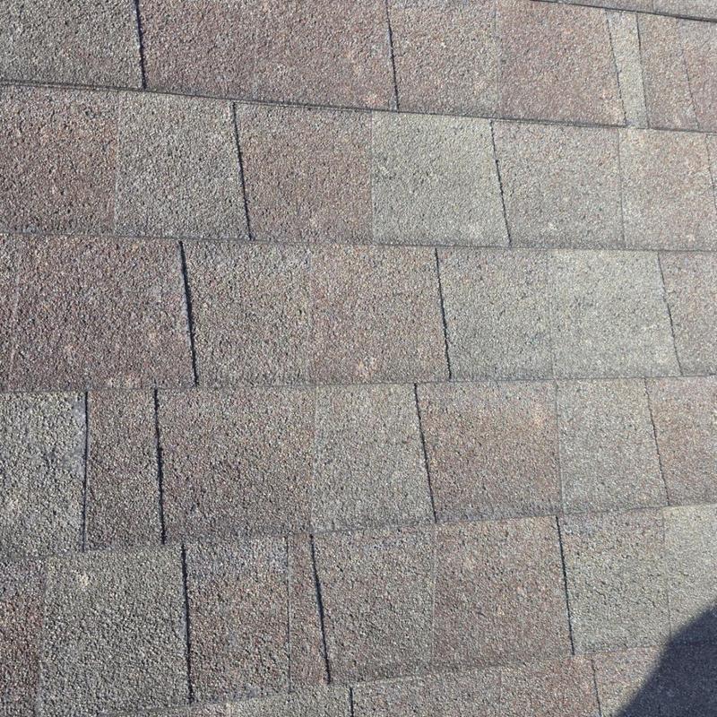 Asphalt roof shingles with hail impact damage