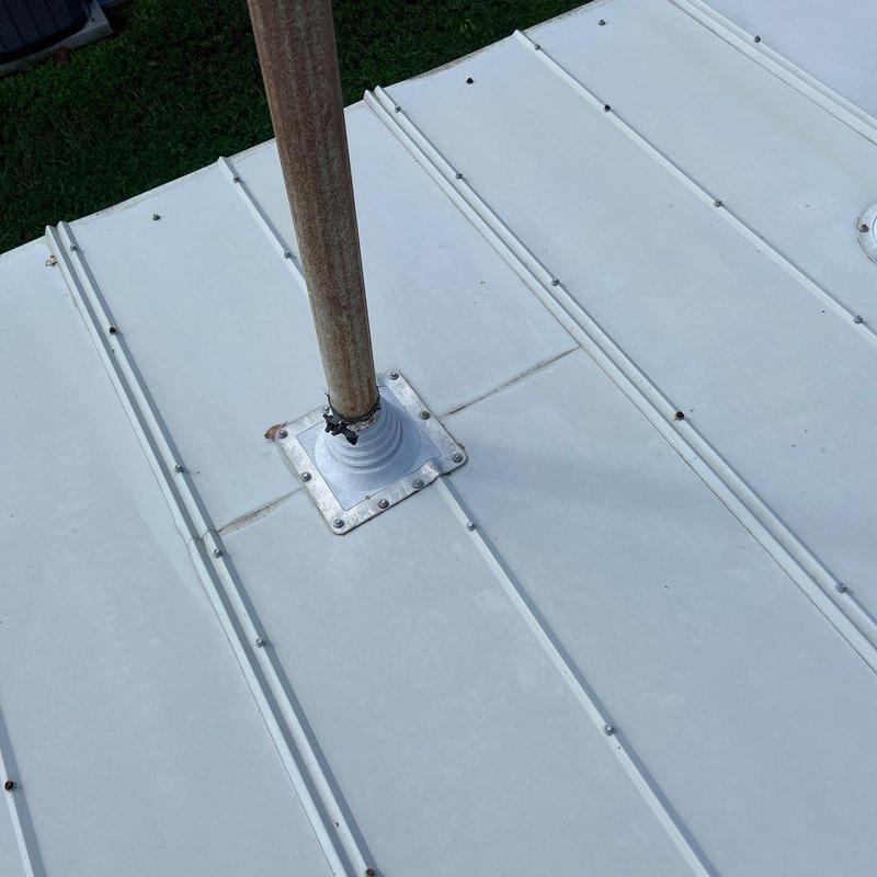 Metal roof pipe flashing with rusted fasteners and seal gaps Metal roof pipe flashing with rusted fasteners and seal gaps