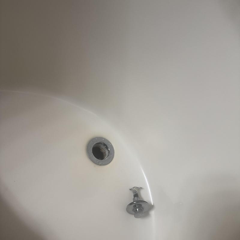 Tub drain with removed stopper in white bathtub