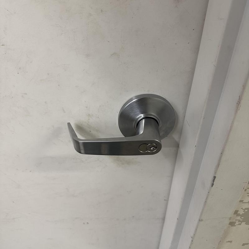 Bathroom door lock with lever handle on white door