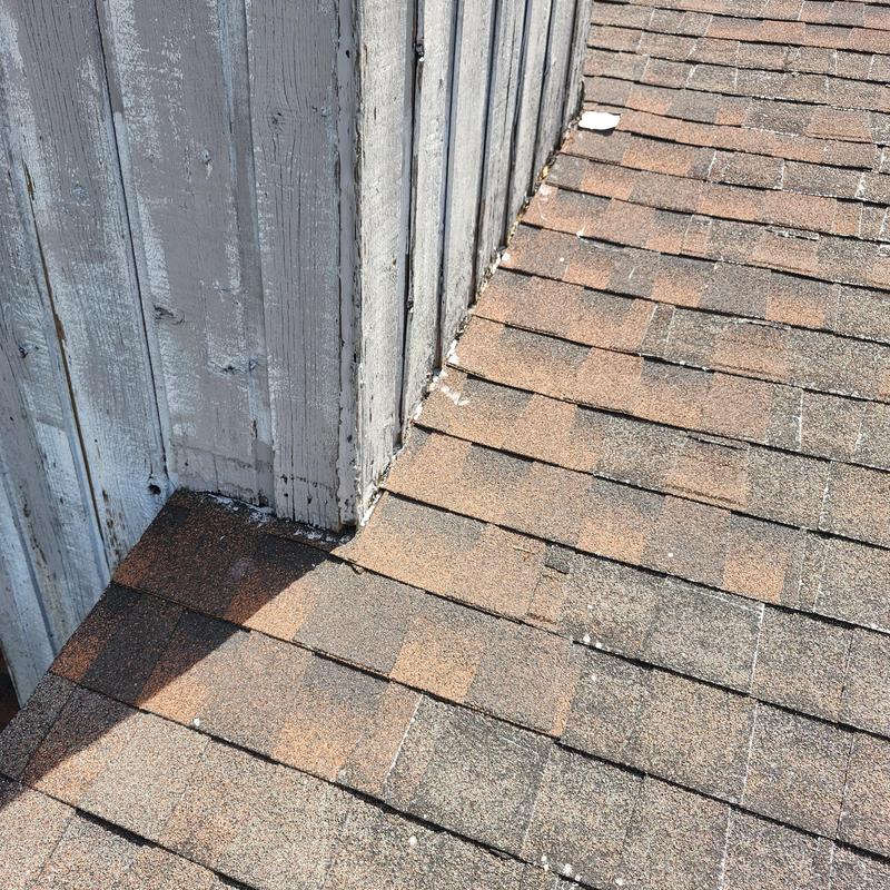 Asphalt shingle roof and wall flashing at roof junction