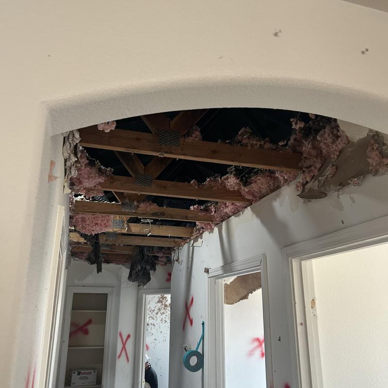 Fire-damaged ceiling with exposed insulation and framing Fire-damaged ceiling with exposed insulation and framing