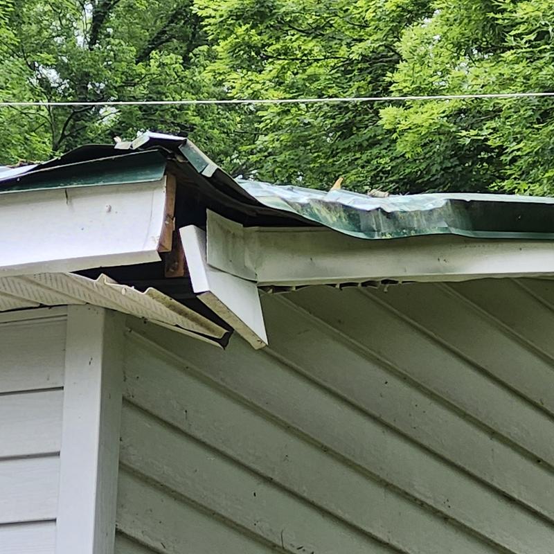 Metal roof and fascia damaged by fallen tree limb