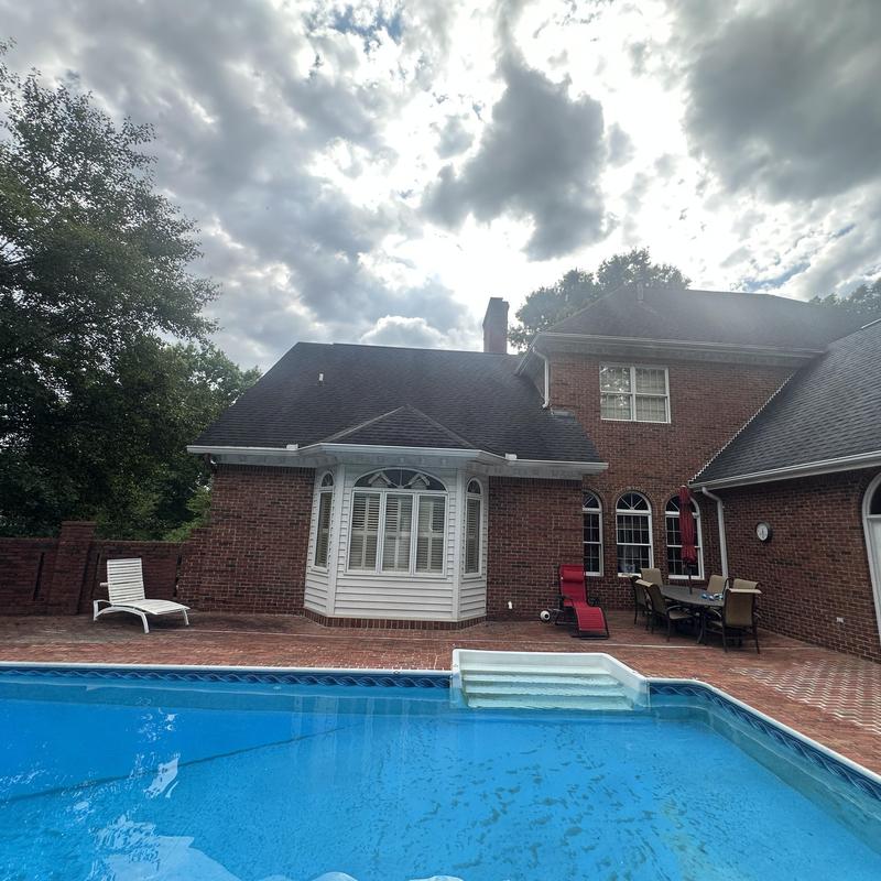 Residential shingle roof over brick home with pool