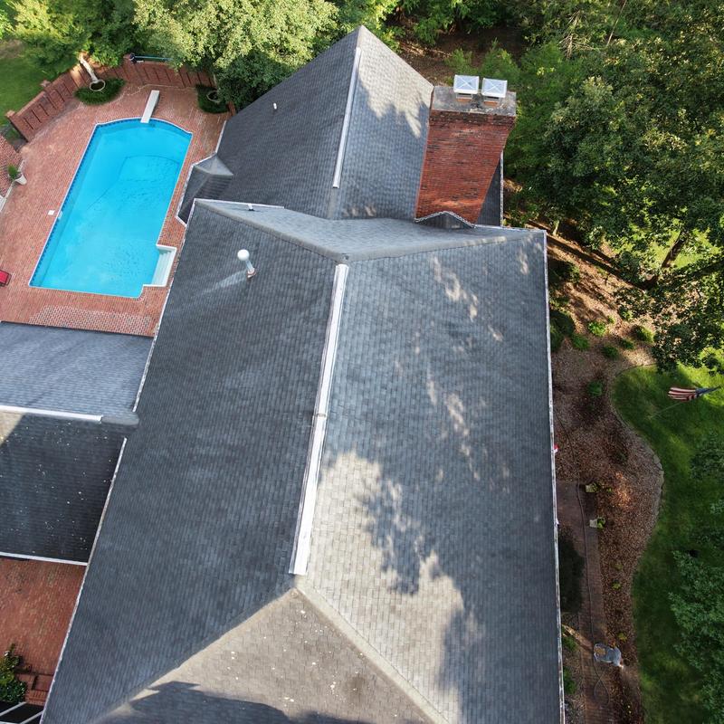 Asphalt shingle residential roof with chimney and pool nearby