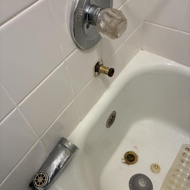 Tub spout diverter removed from bathtub wall for repair