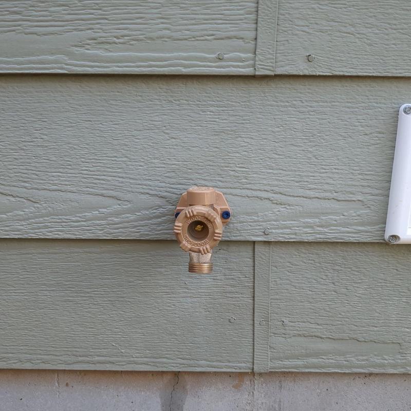 Hose bibb valve on exterior house siding Hose bibb valve on exterior house siding