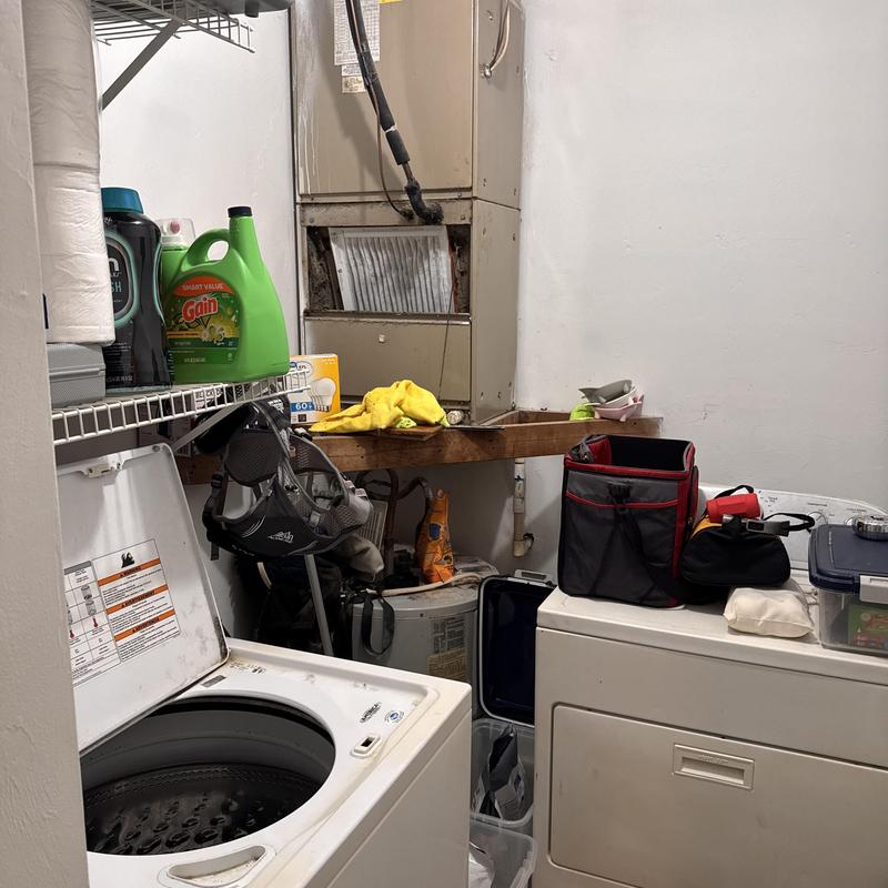 Heat pump split system unit above laundry appliances