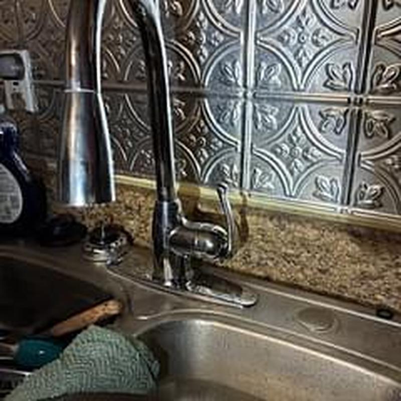 Kitchen faucet installation with metal backsplash